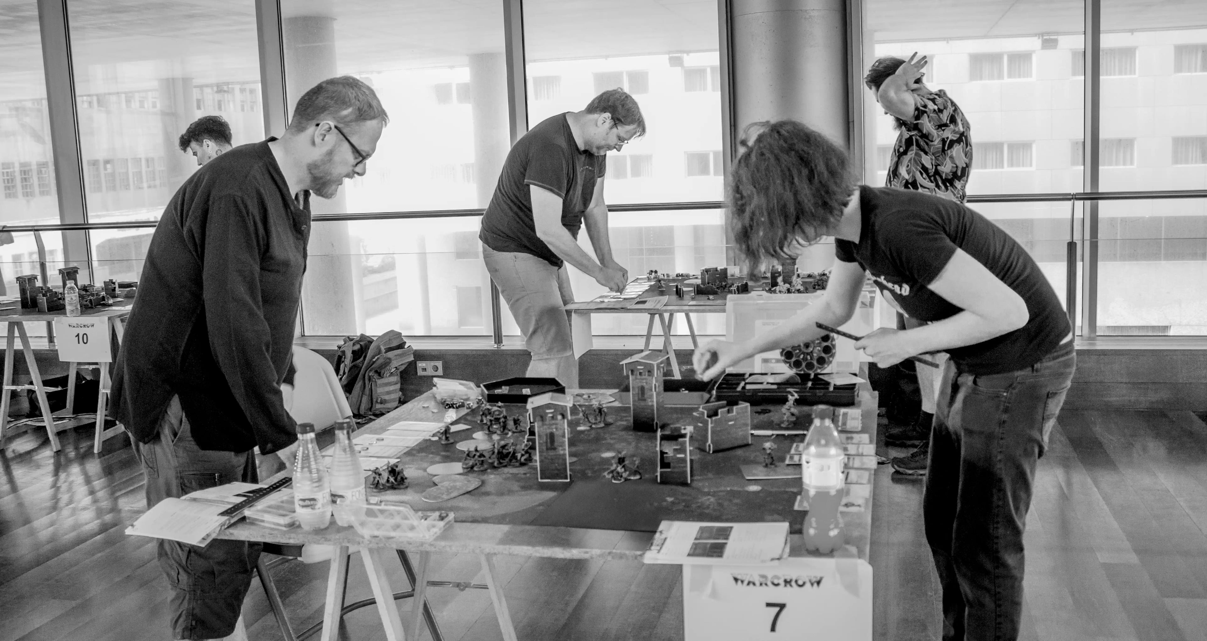 Comunidad de jugadores de Warcrow reunida alrededor de una mesa de juego